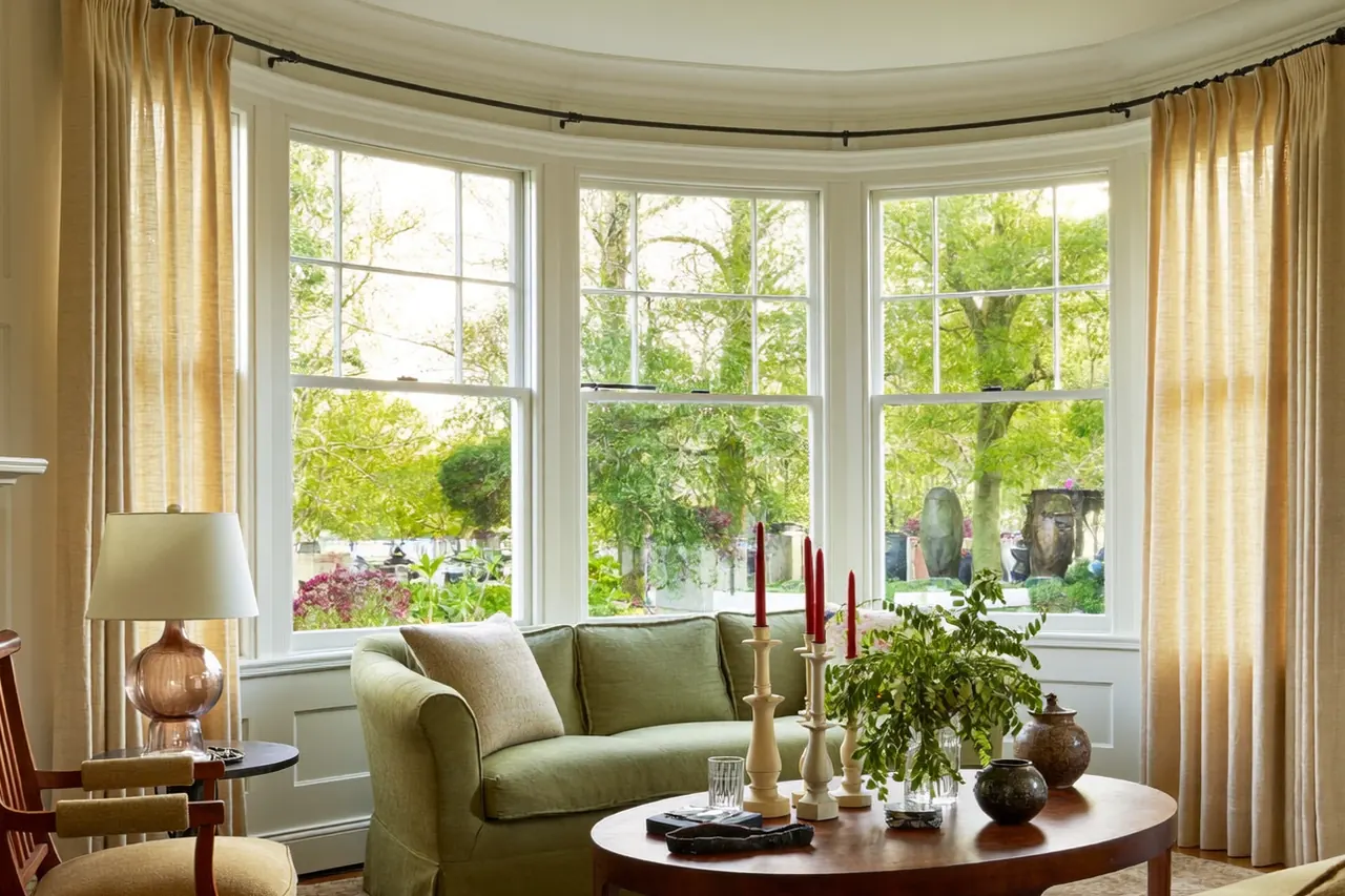 Bright room with new windows shown to buyers by an estate agent