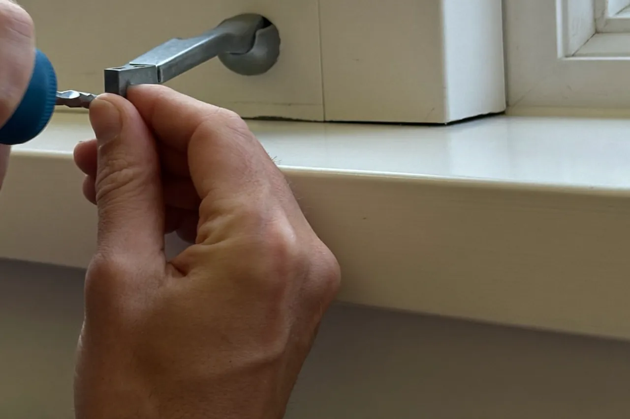 Homeowner wiping down a white window frame with a soft cloth