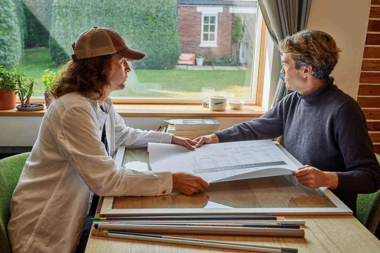 Homeowner and installer discussing a window quote in a hallway